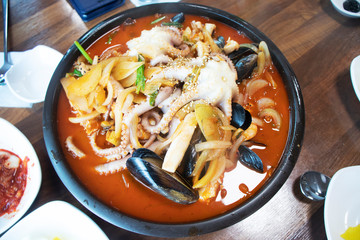 A bowl of spicy red seafood ramen. South Korea. With ingredients of squid, mussels, vegetables, chili pepper sauce. Japanese traditional food mixed with Korean and Chinese style. Popular asian food.