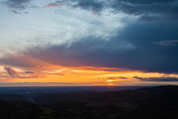 Fototapeta na wymiar Magnifico panorama della pianura padana di Modena, Emilia Romagna, all'alba in estate, con spettacolari colori delle nuvole e del cielo