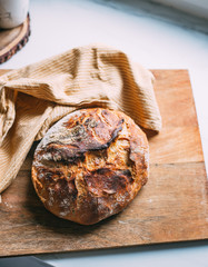 fresh artisan bread on wood tray over marble table with copy space