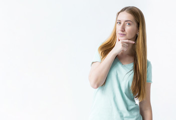 Fototapeta premium portrait of a young beautiful european girl, isolated on white background, looking directly at the camera as if she is solving some secret plan and is enjoying it