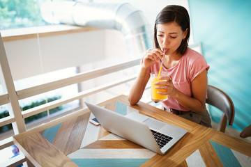 Portrait of a cheerful beautiful woman working, studying on a laptop