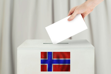 Norwegian Vote concept. Voter hand holding ballot paper for election vote on polling station