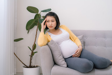 Young expectant, pregnant woman with headache copy space.