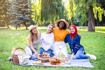 Young multiracial women are on picnic in the park.