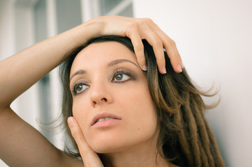 Indoors female portrait of a woman with dreadlocks hairstyle and smoky eyes makeup