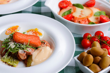 Meat with boiled eggs, lasagna, puff pastry strawberry dessert served on the table. Italian cousine concept.