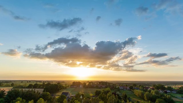 Sch&ouml;ner Sonnenuntergang &uuml;ber einer gr&uuml;nen Landschaft. 4k. UHD Zeitraffer