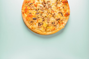 Mushroom pizza vegetarian served on a wooden board over pastel blue mint background. Italian cuisine. Copy space.