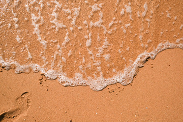 Tourist travel banner design template, copy space. White foam of a sea wave, golden sand beach, turquoise ocean water.