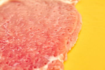 A piece of pork on cutting board after tenderizing is prepared for cooking