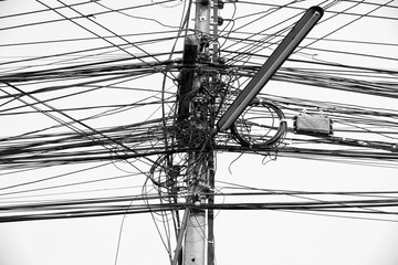 Busy high voltage cables With the cable on the electric pole on the sky background, the tangled...