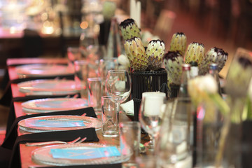 Gala dinner setup with white flowers and blue place cards.