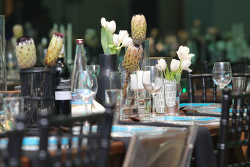 Gala dinner setup with white flowers and blue place cards.