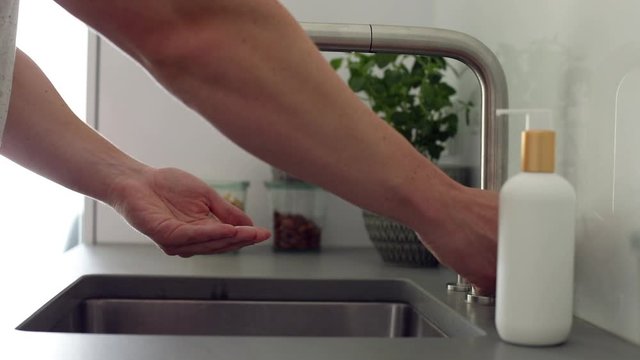 Mann w&auml;scht sich am Waschbecken gr&uuml;ndlich die H&auml;nde mit Seife