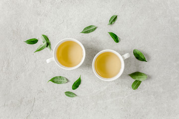 Cup of fresh green tea with tea leaves. Flat lay, top view. Tea concept