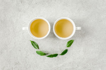 Obraz na płótnie Canvas Cup of fresh green tea with tea leaves. Flat lay, top view. Tea concept