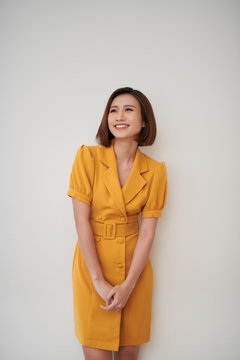 Portrait of a smiling asian business woman standing isolated over white background