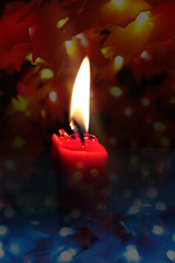 Red candle isolated on black background with flashing Lights