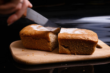 Homemade gray bread on a black background. Photo in section.