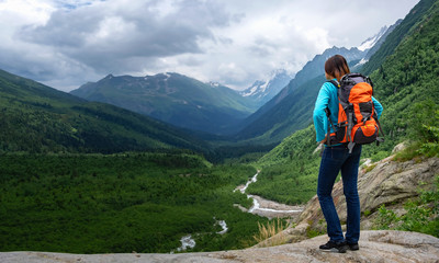 Fototapeta na wymiar Backpacker on top of a mountain enjoying valley view