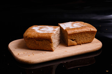 Homemade gray bread on a black background. Photo in section.