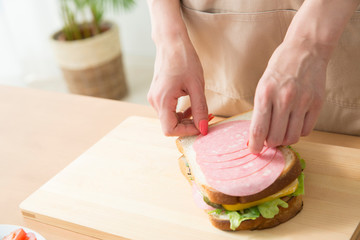サンドイッチを作る女性の手元