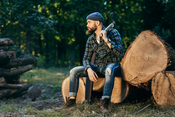 Fototapeta premium Portrait of a bearded brutal woodcutter holding ax in hand