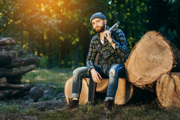 Fototapeta premium Portrait of a bearded brutal woodcutter holding ax in hand
