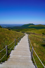 Fototapeta na wymiar wooden long staircase for access on mountain Puy de Dôme volcano in Auvergne france