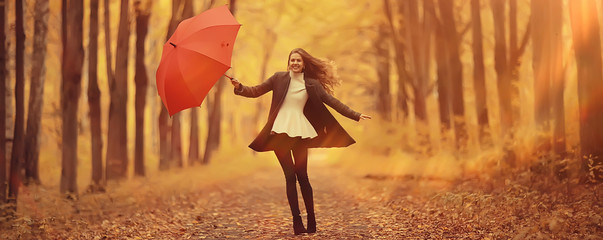 young woman dancing in an autumn park with an umbrella, spinning and holding an umbrella, autumn...