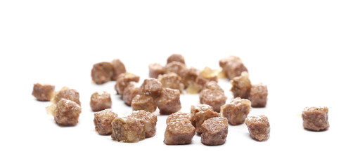 Dog food chunks, wet cubical pieces pile isolated on white background