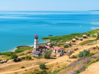 Fototapeta na wymiar coast of the Azov sea, resting place - small huts and a lighthouse
