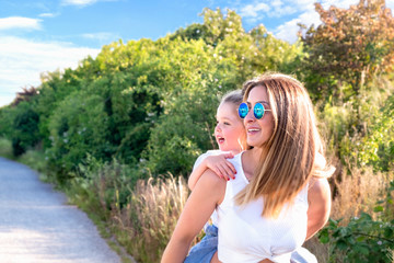 Mom and her pretty little daughter in a summer meadow