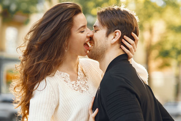 Cute couple in a city. Man in a black jacket. People walks.