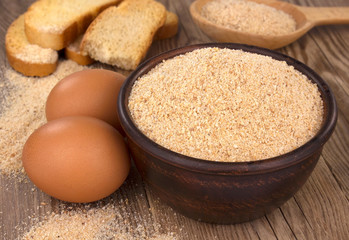 Bowl with breadcrumbs on wooden table