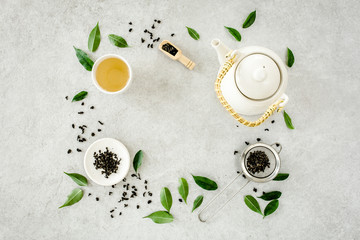 Fototapeta na wymiar Herbal tea with two white tea cups and teapot, with green tea leaves. Flat lay, top view. Tea concept