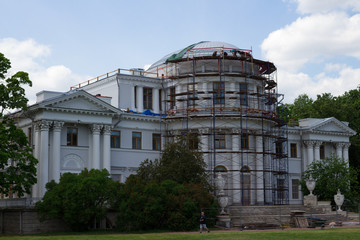The Palace during the restoration of the dome against a blue sky with clouds.