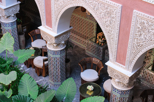 Top view of the Moroccan Riad with original tables and chairs, carved arches and mosaic columns, Marrakech, Morocco