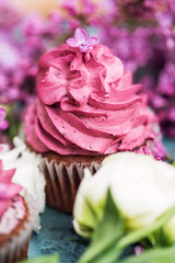 Pink cupcake with white roses, purple lilac