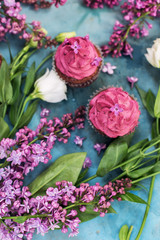 Obraz na płótnie Canvas Purple cupcakes with purple lilac and white rose