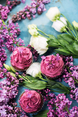 Three pink cupcakes with bouquet of lilac and white roses