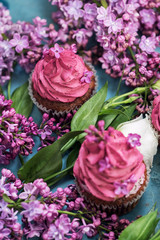 Two pink cupcakes with lilac and white rose