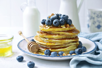 Hot homemade delicious pancakes with fresh blueberry, almond and honey.
