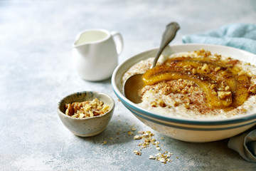 Delicious oat porridge with caramelized banana and nuts for a breakfast.