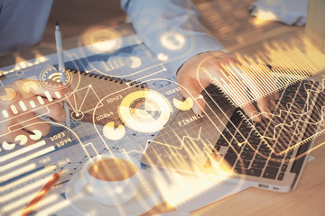 Technology theme hologram with man working on computer on background. High tech concept. Multi exposure.