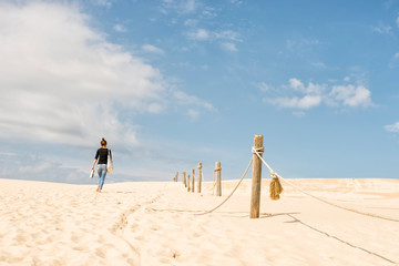 Barefoot woman walking on the sand dunes in the Slowinski National Park in Leba, Poland
