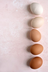 White and beige raw chicken eggs. Top view with copy space.