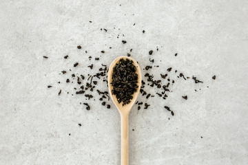 Dry tea leaves on gray background