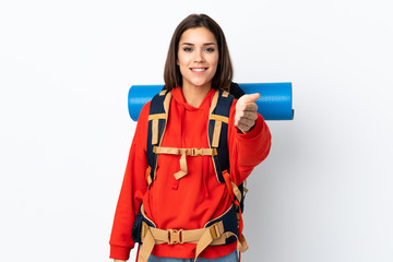 Young caucasian mountaineer girl with a big backpack isolated on white background handshaking after good deal