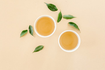 Cup of fresh green tea with tea leaves. Flat lay, top view. Tea concept